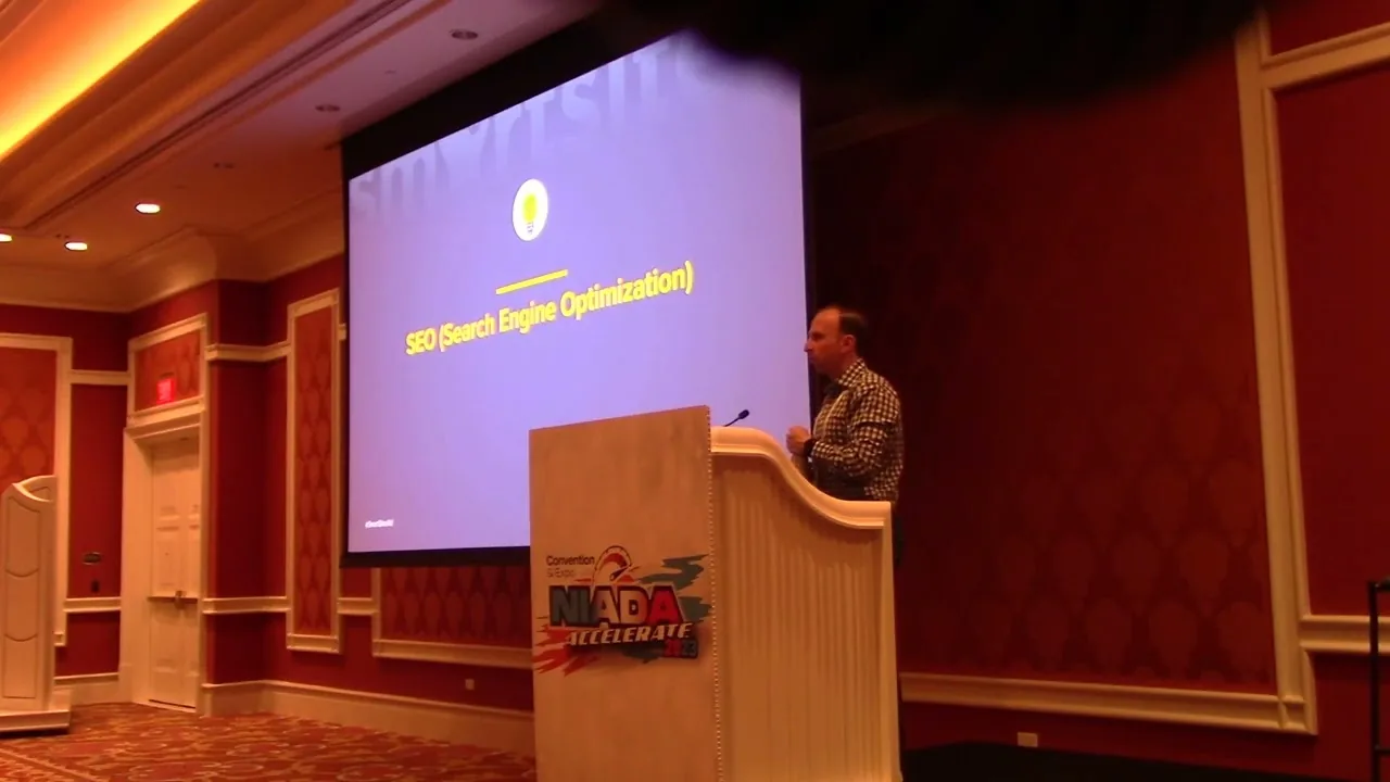 Alex Melen speaking on stage